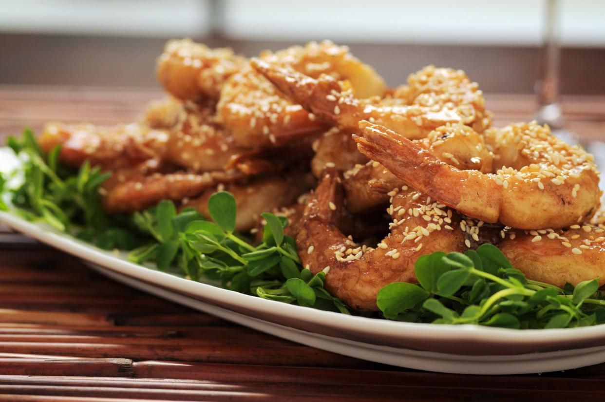 Tail-on prawns with sesame and honey on a bed of pea shoots.
