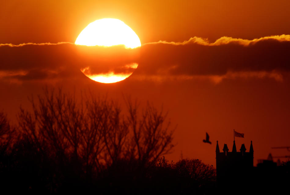 The sun balances next to St Albans Church in Earsdon, North Tyneside, as the sun set last night. PRESS ASSOCIATION Photo. Picture date: Monday April 20, 2015. Britain's is set to bask in sunshine today with temperatures expected to equal the holiday resort of Ibiza. See PA story WEATHER Hot. Photo credit should read: Owen Humphreys/PA Wire