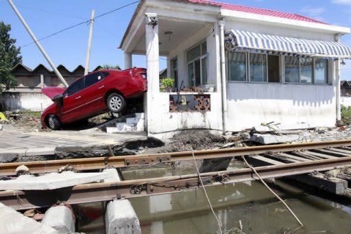 A damaged car is seen washed up at a railway crossing after a storm hit Beijing, blowing off rooftops, on July 22. Beijing residents reacted angrily on Monday after the worst rains to hit the Chinese capital in more than 60 years left at least 37 people dead, with another seven still missing