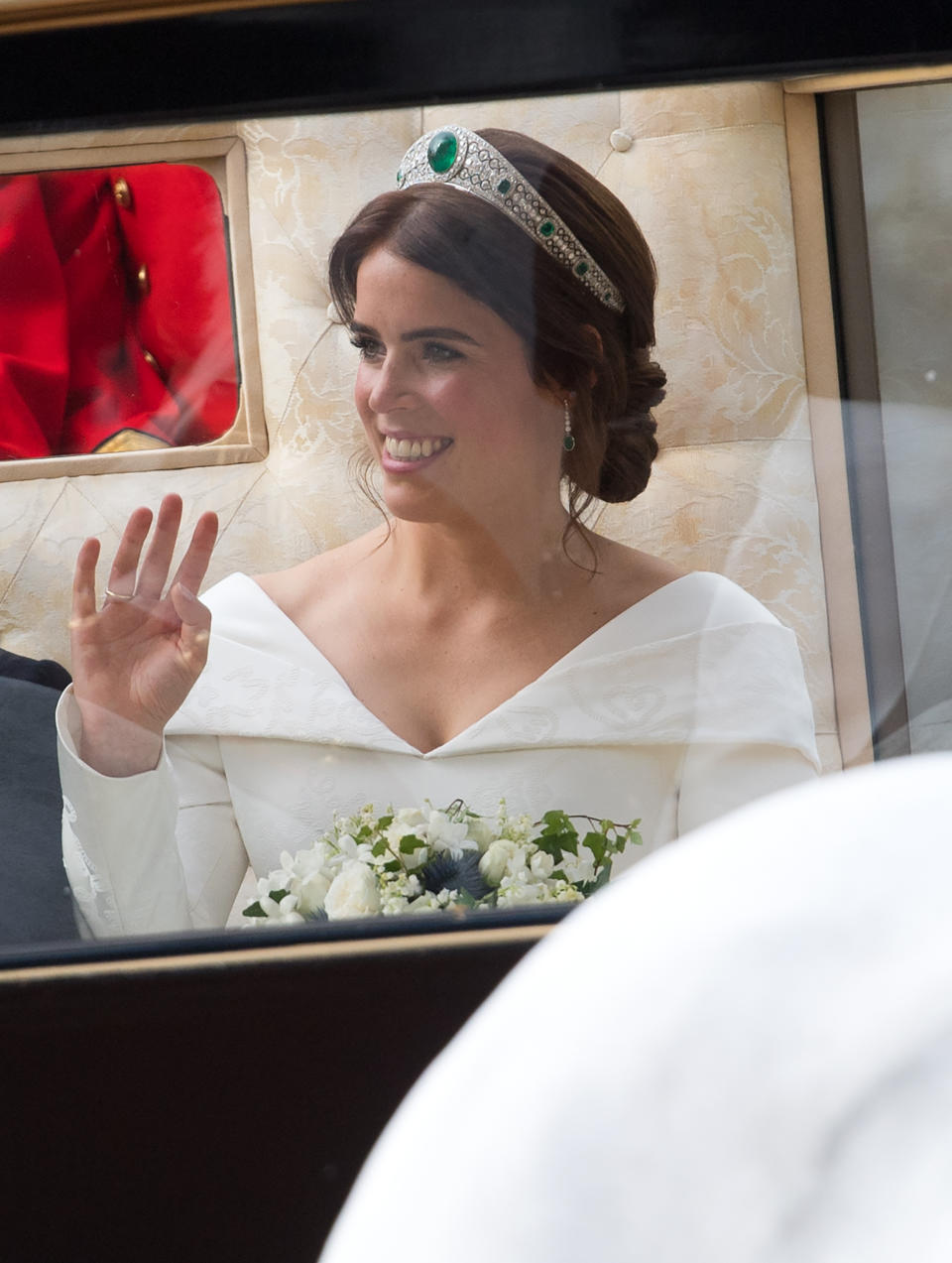 Princess Eugenie of York waves to the crowds from her carriage following their wedding ceremony at St. George's Chapel in Windsor Castle on October 12, 2018