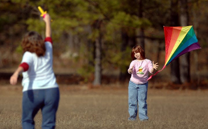 FILE - Tina Bovier and her daughter Danielle, 9, take advantage of warm weather by flying a kite at Diamond Lakes Regional Park in south Augusta.