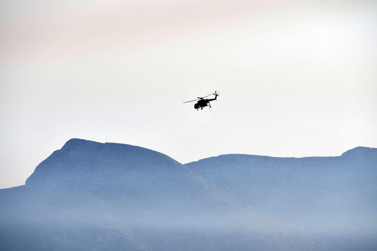 An helicopter takes part in a search and rescue operation near the eastern Aegean Sea island of Samos, Greece, Wednesday, July 13, 2022.
