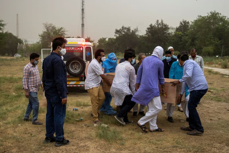 People bury the bodies of COVID-19 victims in New Delhi