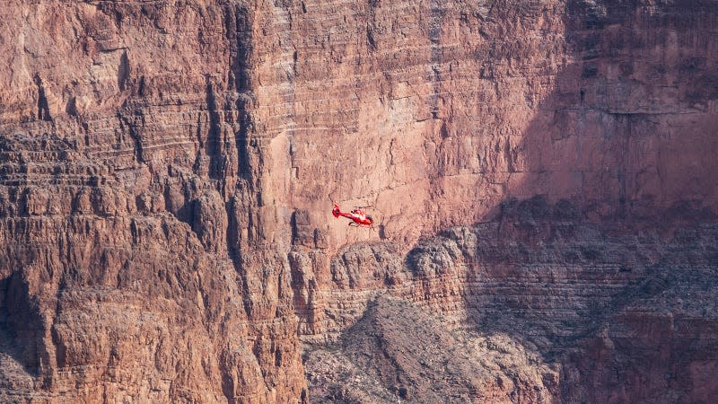 A photo of a helicopter flying through the Grand Canyon. 
