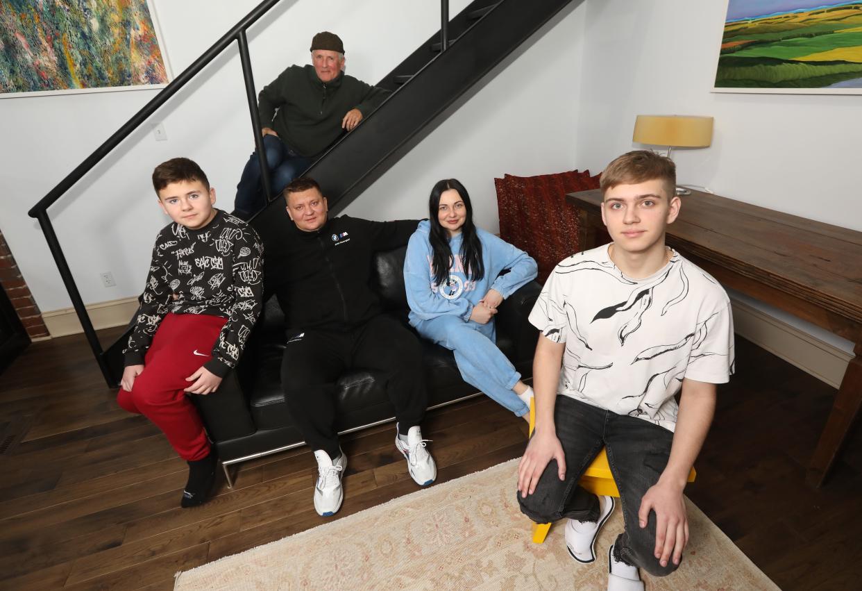 The Schamota family of Dnipro Ukraine will have a safe place to spend the holidays and beyond while being hosted by Tim Taylor (seated on the stairs) and his wife Carmen Fernandez (not pictured) at their home in Norwich. Andrii, 16, left, his mother Kateryna, father Roman and brother Dmytro, 11, arrived in Ohio on Dec. 13.