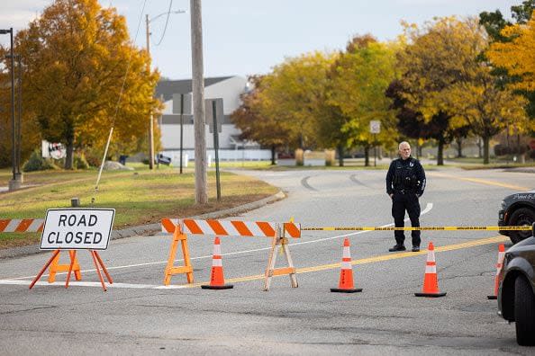 LEWISTON, MAINE - OCTOBER 26: A police officer blocks access to the road to Sparetime Recreation on October 26, 2023 in Lewiston, Maine. Police are still searching for the suspect in the mass shooting, Robert Card, who killed over 15 people in two separate shootings.  (Photo by Scott Eisen/Getty Images)
