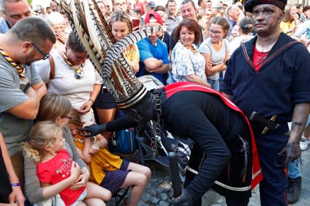 "The Savage", a white performer in a blackface disguise, greets children during the festival Ducasse d'Ath in Ath