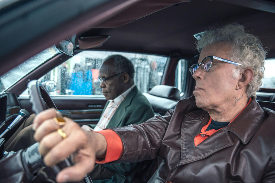 Tom Waits drives a car with Danny Glover in the passenger seat