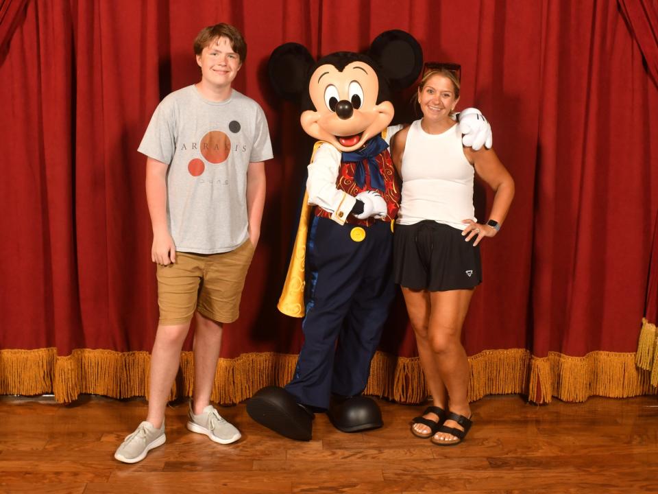 terri and her son posing with mickey mouse at disney world