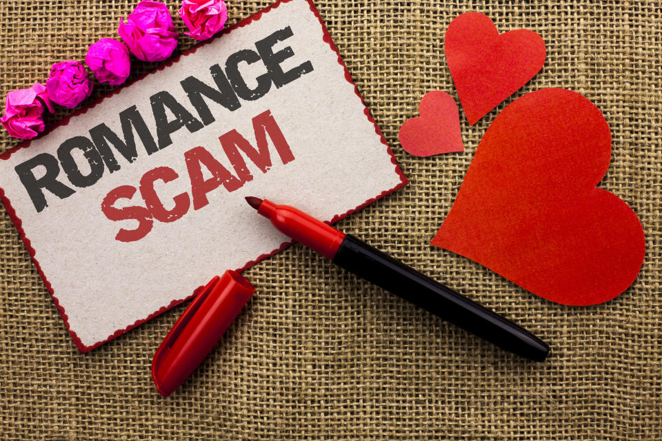 Word writing text Romance Scam. Business concept for Dating Cheat Love Embarrassed Fraud Cyber Couple Affair written Cardboard Piece the jute background Marker and Hearts next to it.