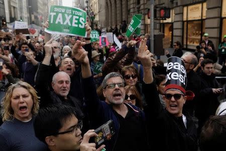 Demonstrators gestures as they march past Trump Tower while protesting through Manhattan demanding U.S. President Donald Trump release his tax returns, U.S., April 15, 2017. REUTERS/Lucas Jackson