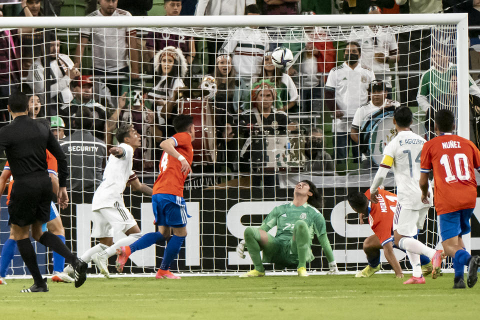 Mexico goalkeeper Carlos Acevedo Lopez, center, watches the ball go into the net on a goal by Chile forward Ivan Morales (11) during the first half of an international friendly soccer match Wednesday, Dec. 8, 2021, in Austin, Texas. (AP Photo/Michael Thomas)