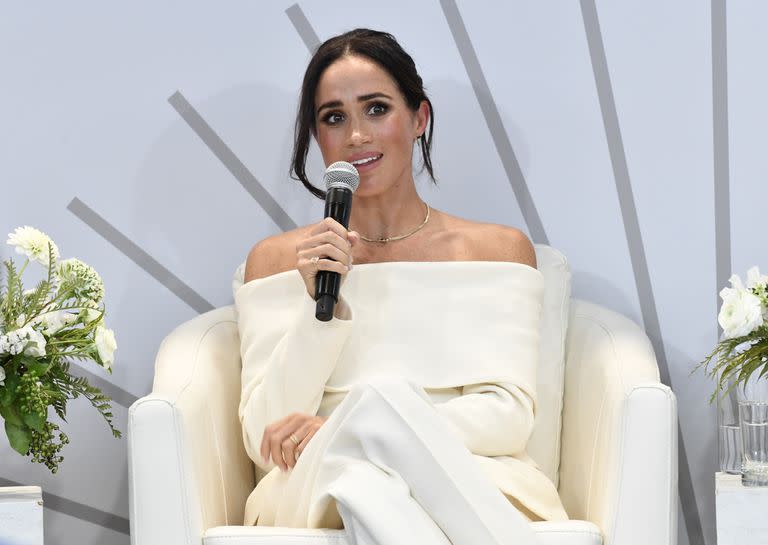 Para esta cita, Markle eligió un traje sastre muy sexy compuesto por una americana con escote bardot que dejaba los hombros al descubierto y un pantalón de corte palazzo, todo en un sofisticado color blanco. La duquesa lo combinó con unos stilettos beige y accesorios de esmeraldas y diamantes