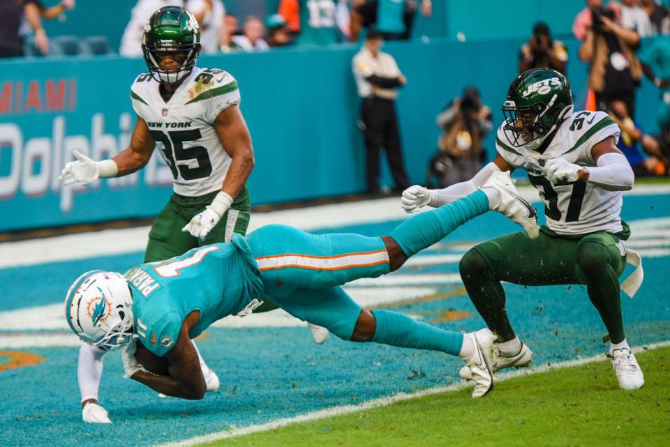 Dolphins receiver DeVante Parker falls into the end zone with the game-winning touchdown reception from Tua Tagovailoa late in the fourth quarter, beating Jets defensive backs Sharrod Neasman (35) and Bryce Hall (37).
