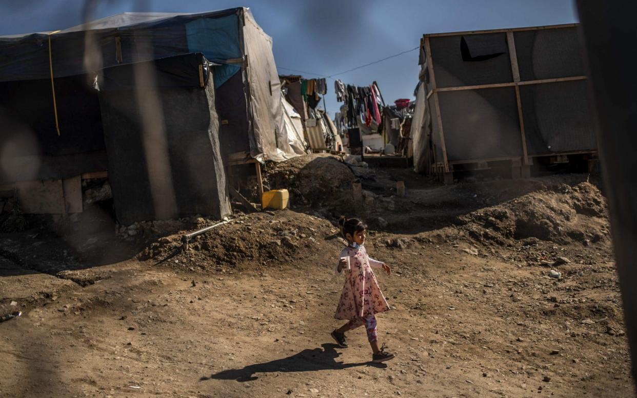 A girl walks between tents at a makeshift camp next to the Samos refugee camp (file photo) - ANGELOS TZORTZINIS/AFP via Getty Images