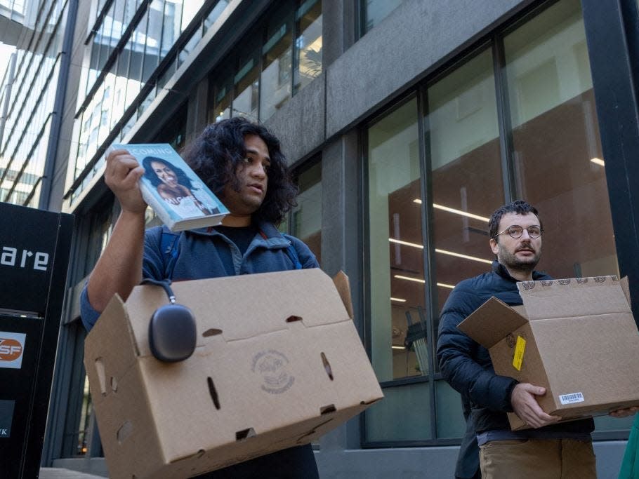 Two people who claim to be Twitter employees, speak with reporters outside Twitter headquarters on October 28, 2022, in San Francisco, California. It later emerged that they were likely practical jokers pretending to be laid off Twitter staff.