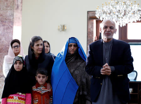 Afghanistan's President Ashraf Ghani (R) speaks to the media after Sharbat Gula (2nd R), the green-eyed "Afghan Girl" whose 1985 photo in National Geographic became a symbol of her country's wars, arrived in Kabul, Afghanistan November 9, 2016. REUTERS/Mohammad Ismail