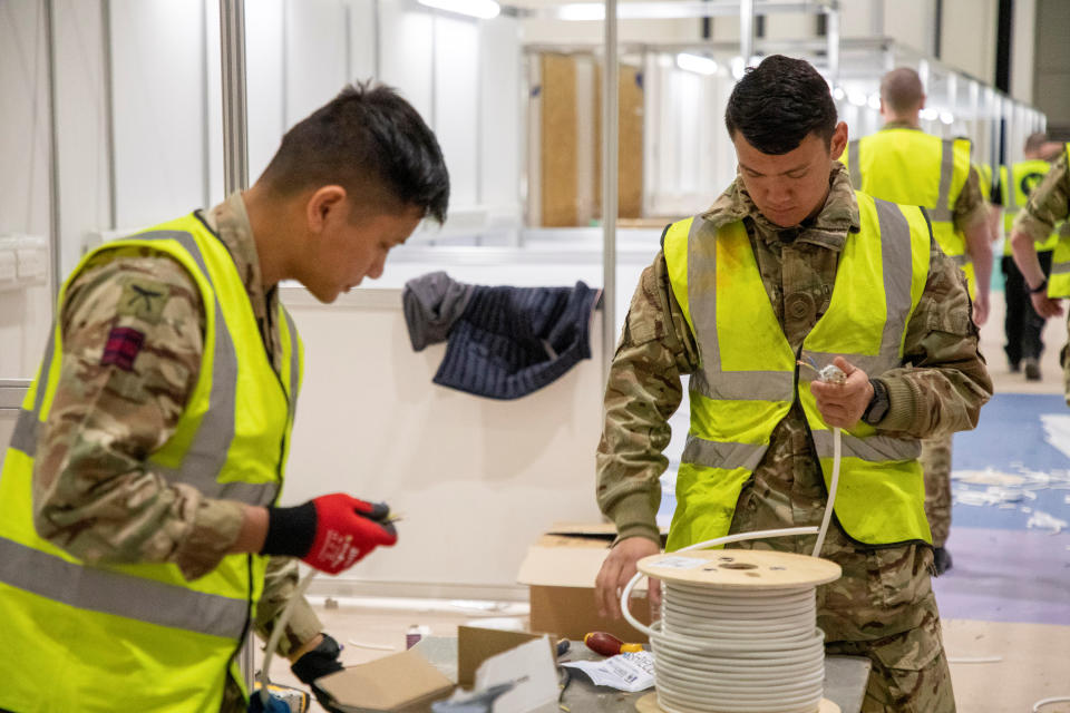 Members of the Queen's Ghurka Engineers Regiment, 36 Engineer Regiment, help to build the hospital.