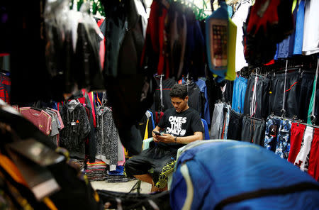 A resident manning a clothes shop uses a mobile phone to surf internet in Paranaque, Metro Manila, Philippines July 7, 2016. Picture taken July 7, 2016. REUTERS/Erik De Castro