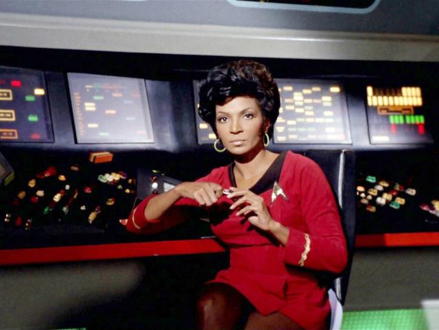 A woman in a red Star Trek dress at a control panel