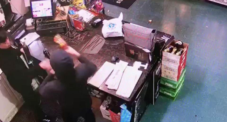 After breaking a bottle on the counter, CCTV footage shows a man approaching Mr Jeon with the broken glass. Source: Supplied