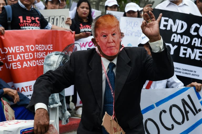 An environmental activist wearing a face mask depicting US President Donald Trump takes part in a Bangkok demonstration