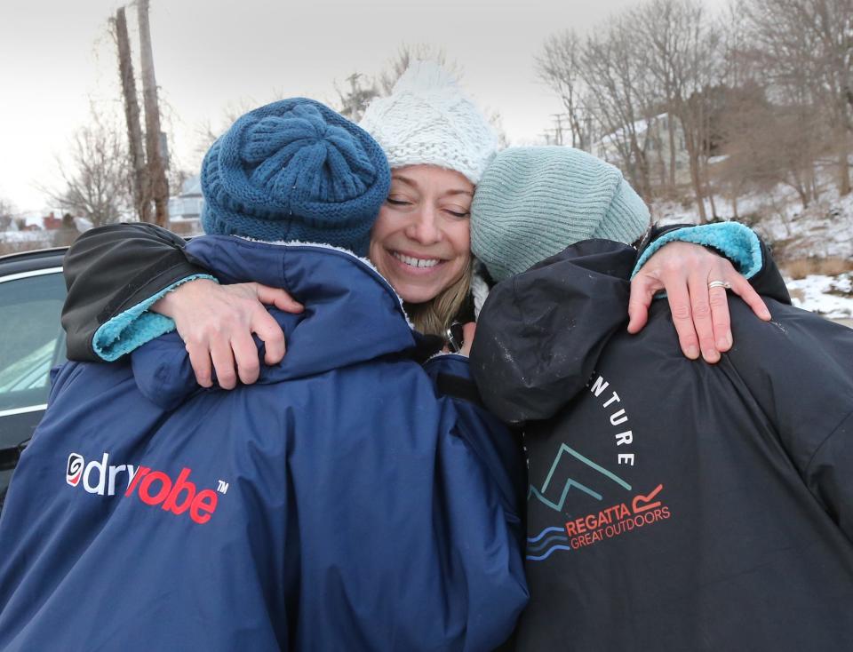 Amy Hopkins, of Saltwater Mountain Company, embraces dippers Tricia Monaghan and Amy Clark after they took the plunge into the ocean on Jan. 19, 2024.