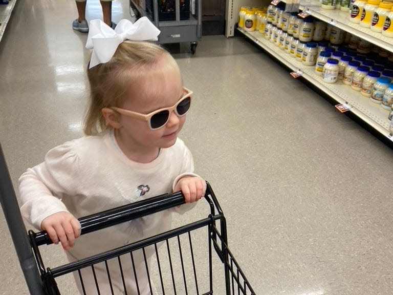 Elliott Harrell's daughter pushing the small cart at the grocery store.