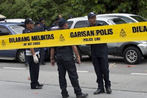 Malaysian policemen inspect one of the site of three small explosions outside the court in Kuala Lumpur. Malaysian opposition leader Anwar Ibrahim was acquitted on Monday in a stunning climax to a two-year sodomy trial and quickly set his sights on ousting the long-ruling coalition in upcoming polls