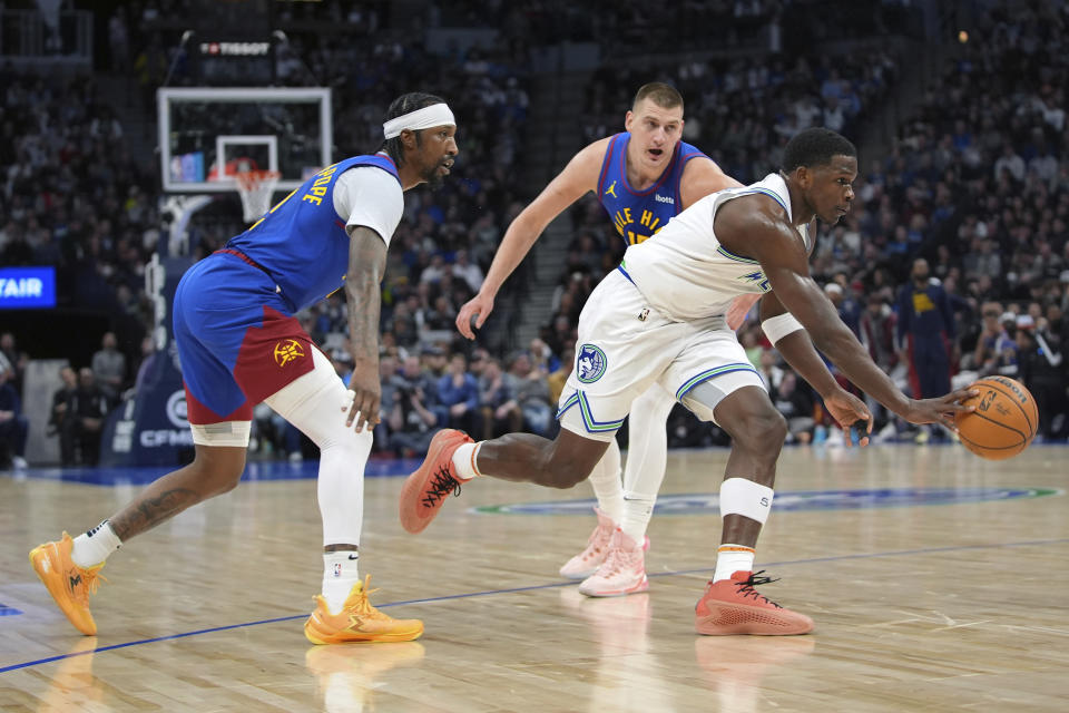 Minnesota Timberwolves guard Anthony Edwards, front right, works toward the basket as Denver Nuggets guard Kentavious Caldwell-Pope, left, and center Nikola Jokic defend during the first half of an NBA basketball game Tuesday, March 19, 2024, in Minneapolis. (AP Photo/Abbie Parr)