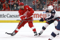 Detroit Red Wings left wing David Perron (57) passes the puck while being chased by Columbus Blue Jackets center Brendan Gaunce (16) during the first period of an NHL hockey game Tuesday, March 19, 2024, in Detroit. (AP Photo/Duane Burleson)
