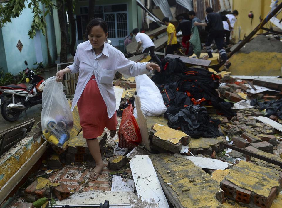 Nguyen Thi Ngoc Chau carries belongings through the remains of her home, which collapsed because of Typhoon Nari, in Vietnam's central Quang Nam province, October 15, 2013. Typhoon Nari knocked down trees and damaged hundreds of houses in central Vietnam early on Tuesday, forcing the evacuation of tens of thousands of people, state media said. More than 122,000 people had been moved to safe ground in several provinces, including Quang Nam and Danang city, by late Monday before the typhoon arrived, the official Tuoi Tre (Youth) newspaper reported. (REUTERS/Duc Hien)