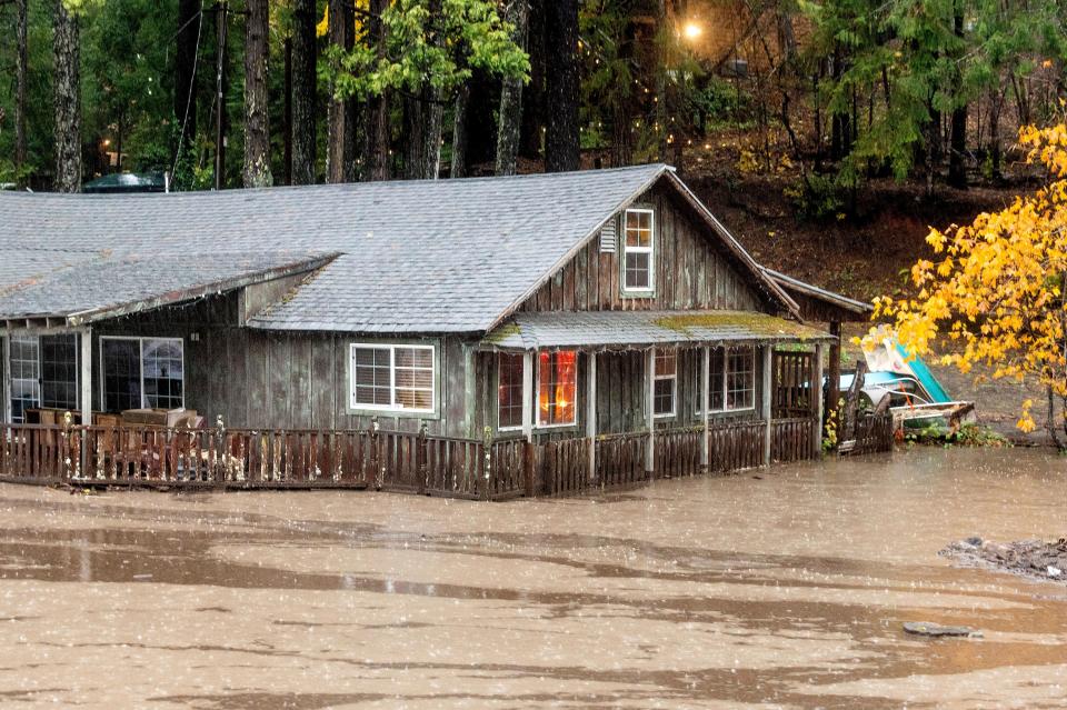 Floodwaters from Lake Madrone flow past a house on Oro Quincy Highway on Sunday, Oct. 24, 2021, in Butte County, Calif.