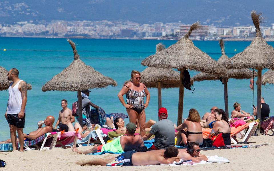 Tourists sunbathe at Palma Beach in Palma de Mallorca - JAIME REINA/AFP