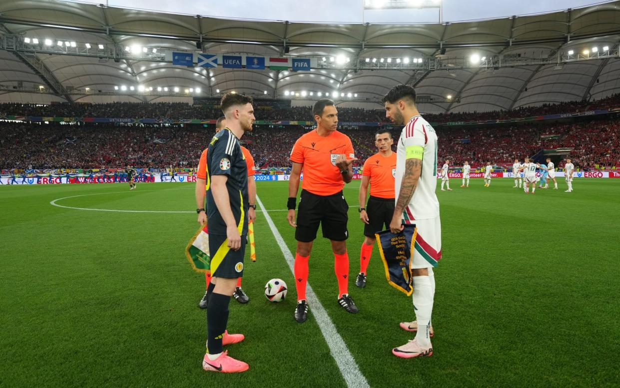 Andrew Robertson of Scotland and Dominik Szoboszlai of Hungary take part in the coin toss