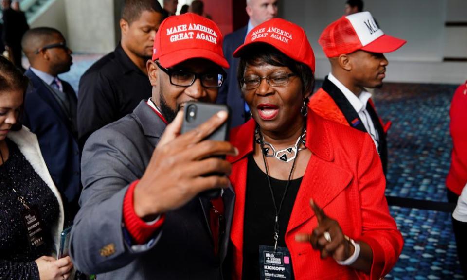 Attendees wearing pro-Trump hats wait to enter the event.