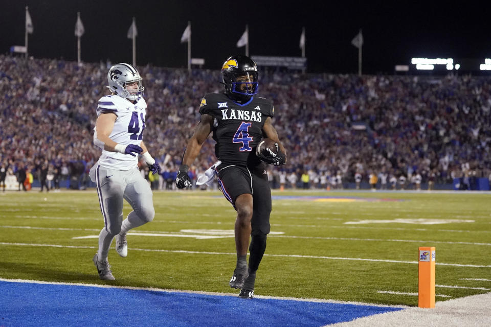 Kansas running back Devin Neal (4) is chased into the end zone by Kansas State linebacker Austin Moore (41) to score a touchdown during the first half of an NCAA college football game Saturday, Nov. 18, 2023, in Lawrence, Kan. (AP Photo/Charlie Riedel)