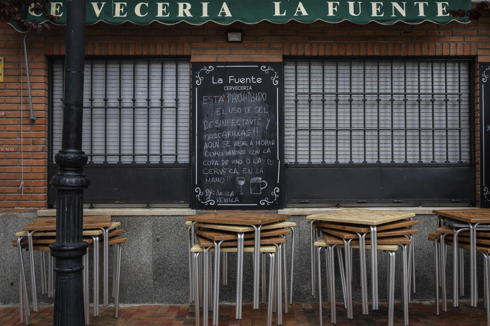 A humorous message written on a blackboard of a closed bar and related to the new coronavirus reads in Spanish "The use of disinfectant gel and masks is prohibited!! Here one comes to die like heroes with a glass of wine or beer in hand!!" in Guadalix de la Sierra, outskirts Madrid, Tuesday, March 17, 2020. According to the World Health Organization, most people recover in about two to six weeks, depending on the severity of the illness. (AP Photo/Bernat Armangue)
