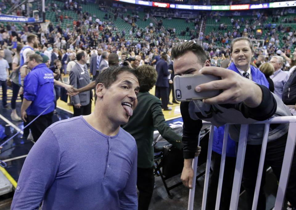 Dallas Mavericks owner Mark Cuban poses with a fan. (AP/Rick Bowmer)