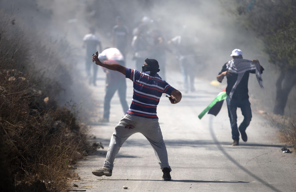 A Palestinian demonstrator uses a slingshot to hurl stones at Israeli troops during clashes as they protest against Israeli Jewish settlements in Asira al-Qibliya near the West Bank city of Nablus, Friday, Sept. 25, 2020. (AP Photo/Majdi Mohammed)