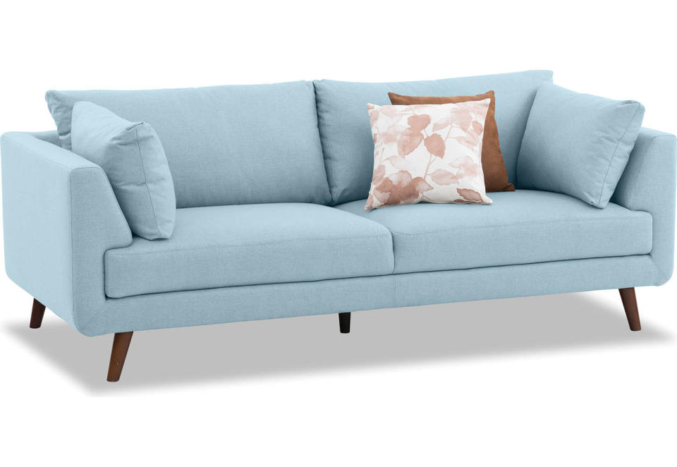 a pale blue Lilou Fabric 3 Seat Sofa sits on a plain white background with two cushions in contrasting colours of brown and autumn leaves.