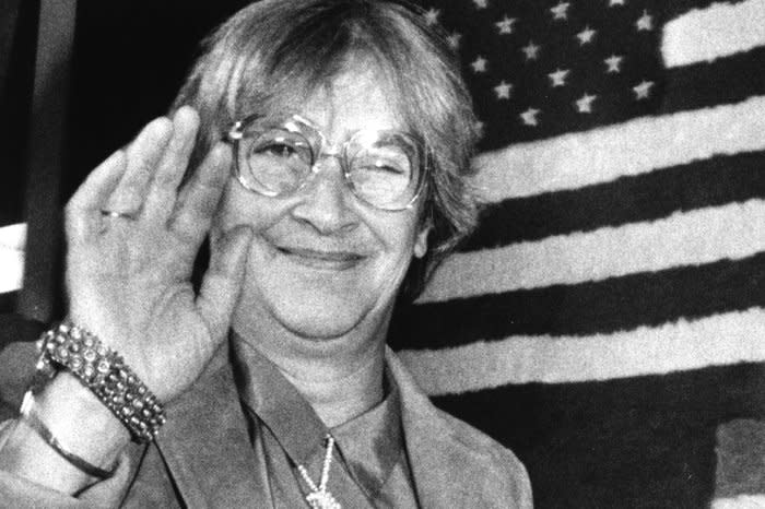 Yelena Bonner, wife of Soviet dissident Andrei Sakharov, waves goodbye as she passes an American flag at Boston’s Logan Airport on May 24, 1986. File Photo by Jim Bourg/UPI