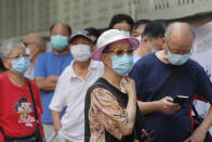People wearing face masks queue for the coronavirus test outside a testing center in Hong Kong, Tuesday, Sept. 1, 2020. Hong Kong began a voluntary mass-testing program for coronavirus Tuesday as part of a strategy to break the chain of transmission in the city's third outbreak of the disease. The virus-testing program has become a flash point of political debate in Hong Kong, with many distrustful over resources and staff being provided by the China's central government and fears that the residents’ DNA could be collected during the exercise (AP Photo/Kin Cheung)
