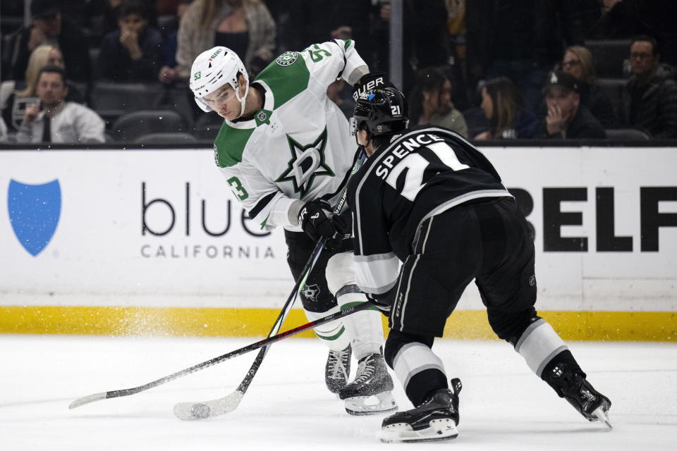 Dallas Stars center Wyatt Johnston (53) shoots as Los Angeles Kings defenseman Jordan Spence (21) defends during the first period of an NHL hockey game, Saturday, March 9, 2024, in Los Angeles. (AP Photo/Kyusung Gong)