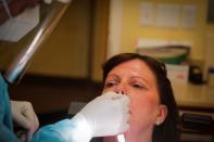 Dr. Vincent Carrao swabs a patient's nose for the coronavirus disease (COVID-19) test at Palisades Oral Surgery, in Fort Lee