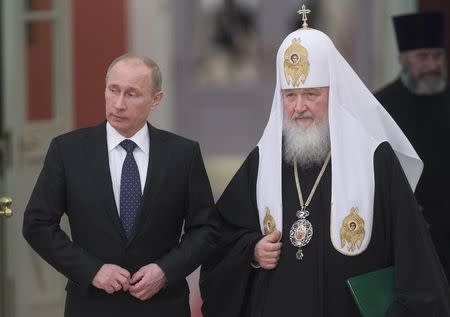 Russia's President Vladimir Putin (L) and Patriarch of Moscow and All Russia Kirill arrive for the meeting with Russian Orthodox church bishops in Moscow February 1, 2013. REUTERS/Sergei Gunyeev/Ria Novosti/Kremlin/Files