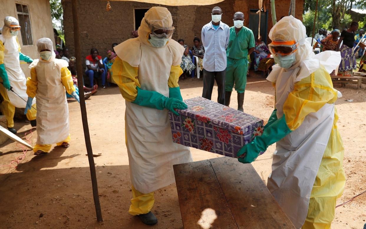 Ebola healthcare workers carry a baby's coffin in the DRC - REUTERS