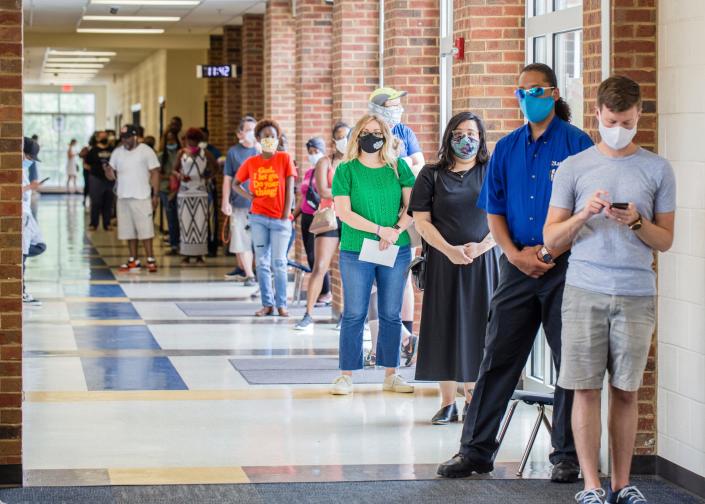 Voters wait in long lines at Peachcrest Elementary School to vote in the state&#39;s primary election on  June 9, 2020, in Decatur, Ga. Coronavirus restrictions only allowed 10 people in the gym at a time so many machines were not being used, creating long wait times.