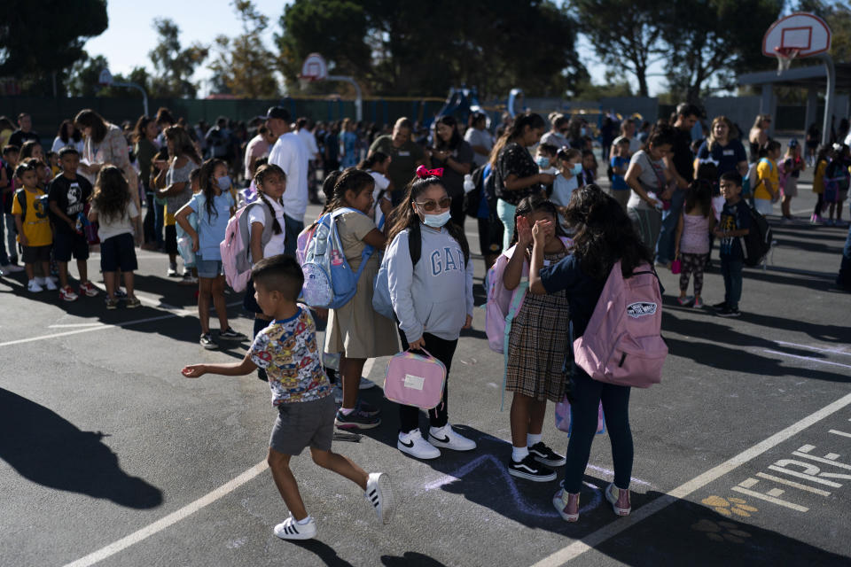 Students wait in line before heading to their classrooms on the first day back to school 