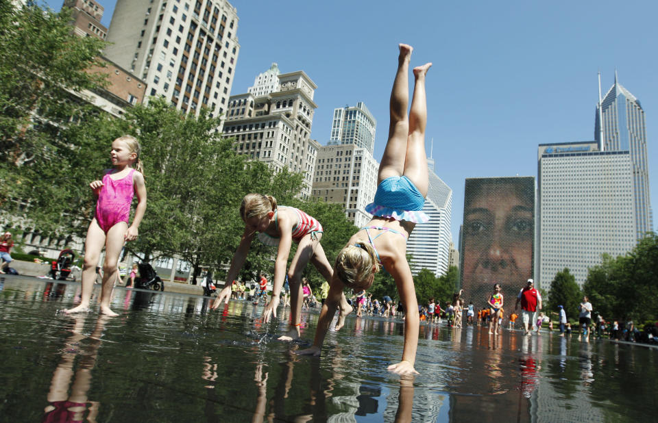 From left, Amelia Schendel, her sister Alison Schendel and Madeline Ahern, all on vacation from Minnesota, enjoy the cool water on a hot summer day at Crown Fountain in Chicago's Millennium Park, Wednesday, June 27, 2012. Temperatures in Illinois are forecast to top 100 degrees by Thursday, and authorities are urging the public to be cautious. (AP Photo/Sitthixay Ditthavong)